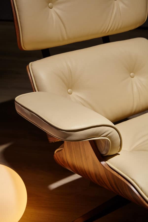 accoudoir copie fauteuil charles eames avec ottoman cuir italien blanc crème bois de palissandre base alu noir dans un salon
