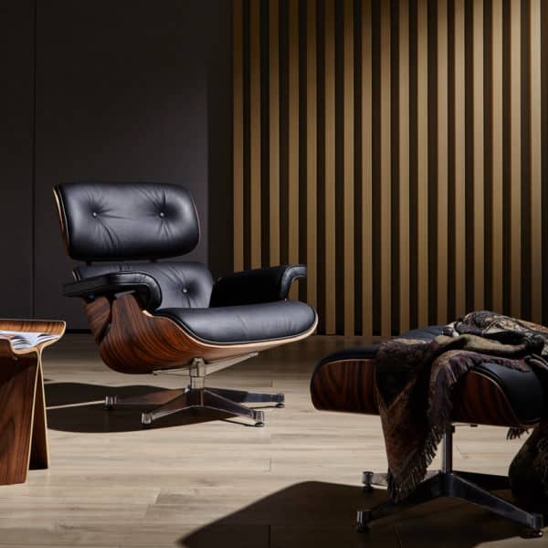copie fauteuil charles eames avec repose pieds cuir italien noir bois de palissandre base en aluminium chromé poli dans un salon lounge