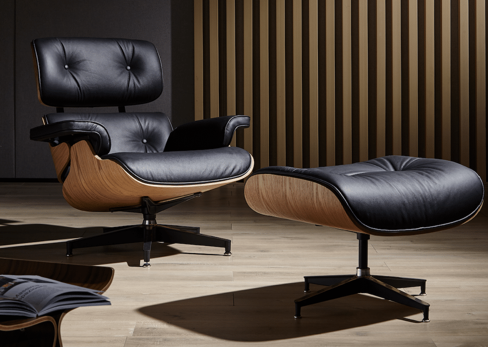 copie fauteuil charles eames avec ottoman cuir pleine fleur noir bois de frêne base alu noir dans un salon lounge